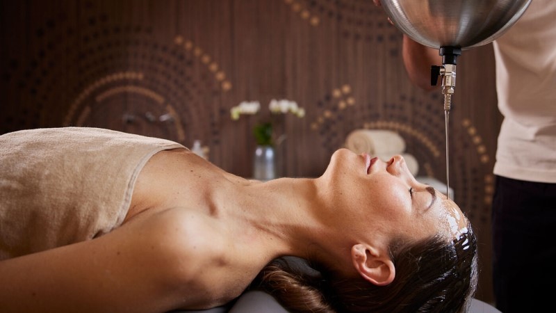 Mulher recebendo tratamento facial com aplicação de produto na região da test