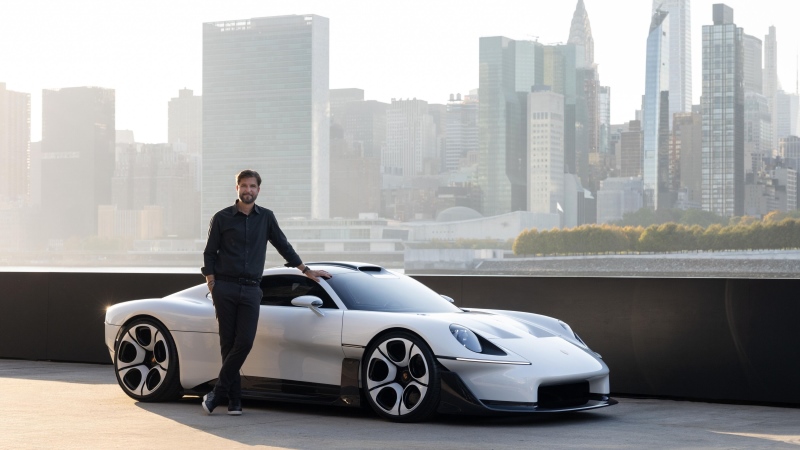 Porsche Mission S estacionado em área externa, visto pela lateral direita, com uma pessoa ao lado